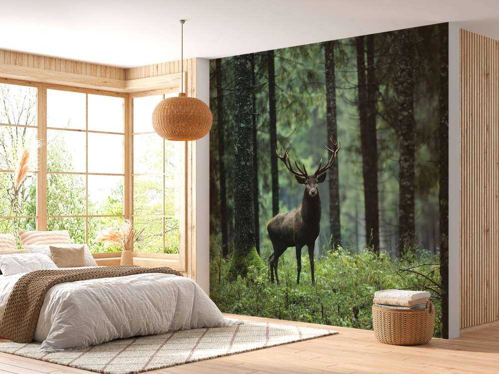 Duży jeleń między drzewami