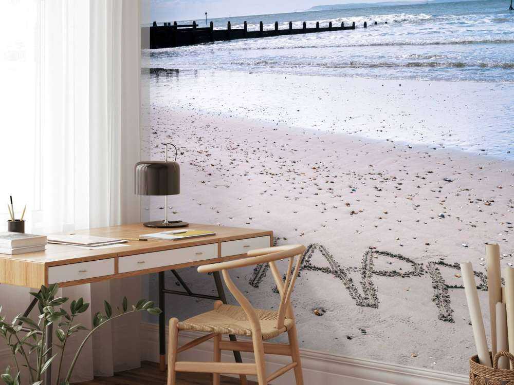 HAPPY message written in smooth sand at the beach