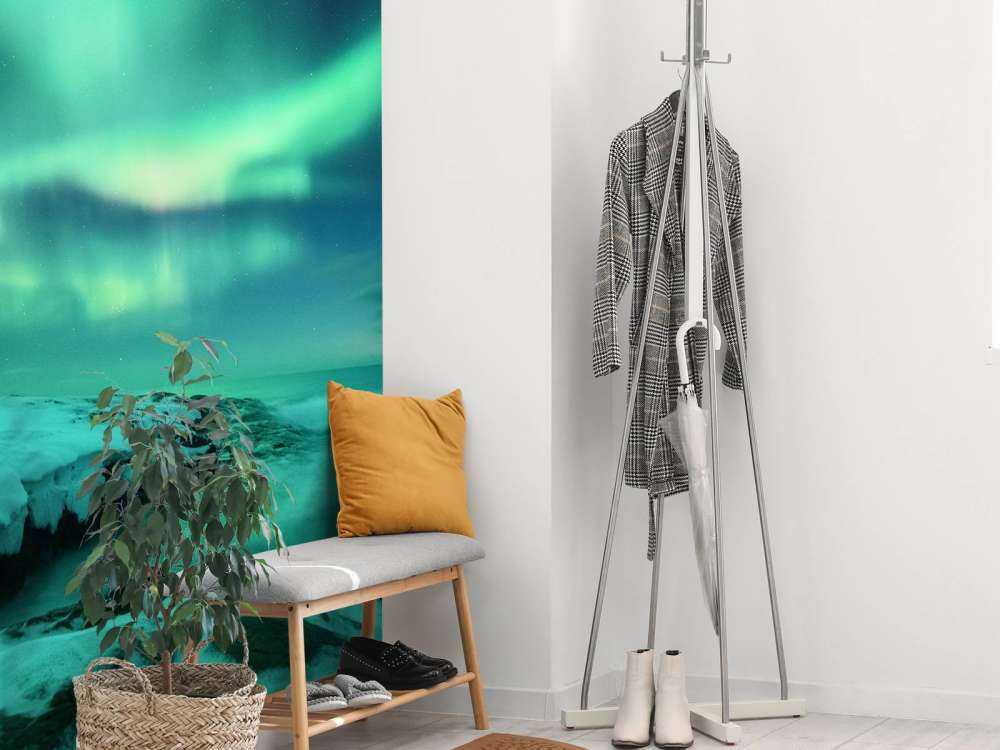 Zielone światła północne nad zaśnieżonymi skałami