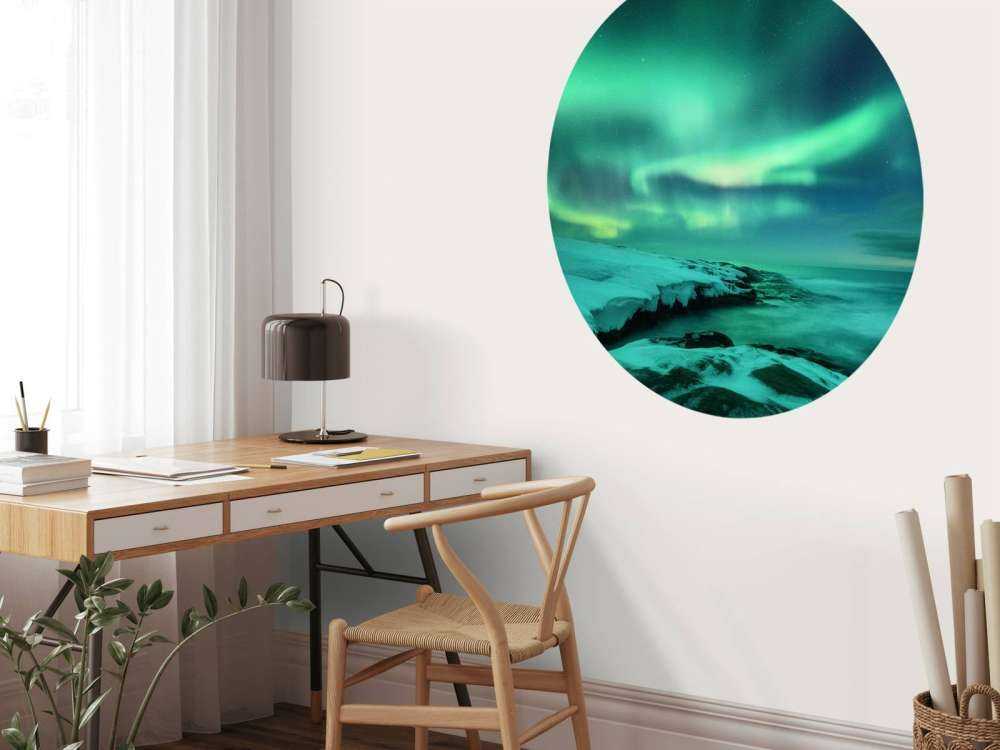 Zielone światła północne nad zaśnieżonymi skałami