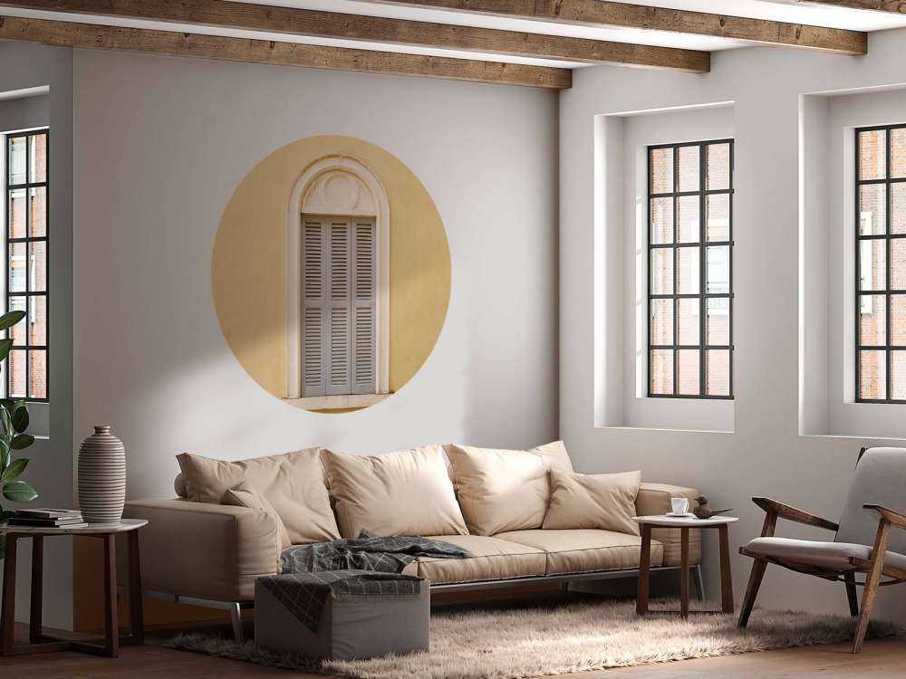 Okno z drewnianymi okiennicami na żółtej ścianie