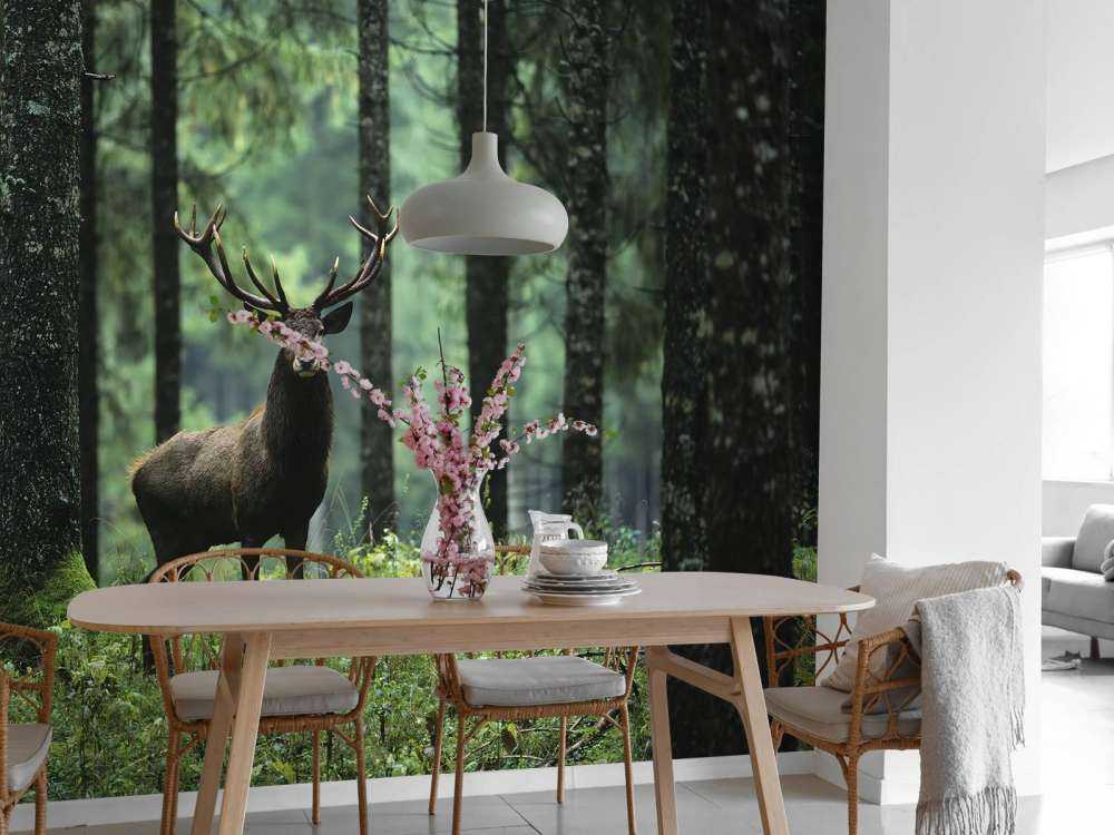 Duży jeleń między drzewami