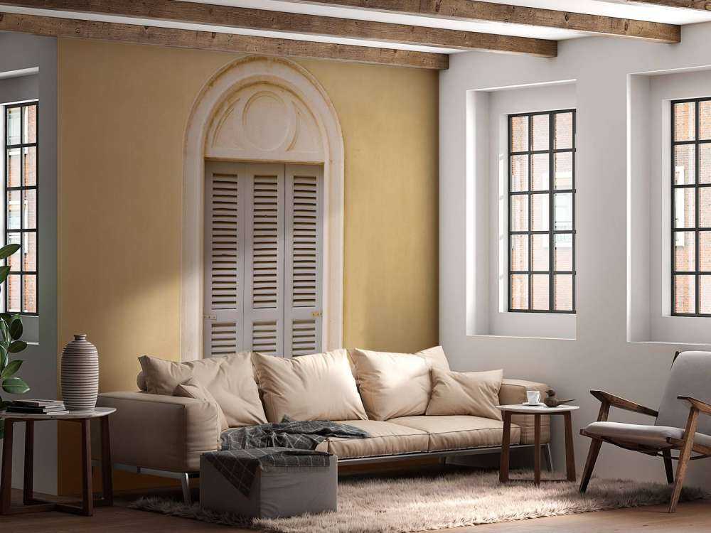 Okno z drewnianymi okiennicami na żółtej ścianie