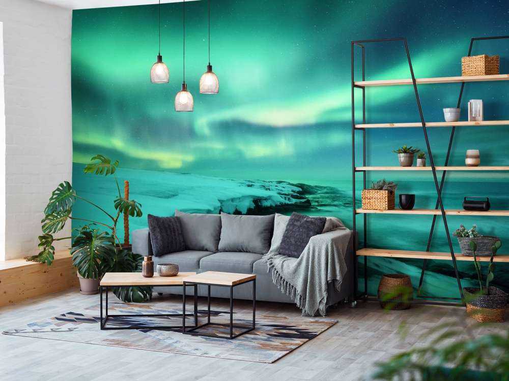 Zielone światła północne nad zaśnieżonymi skałami