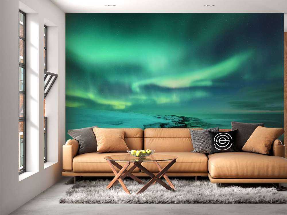 Zielone światła północne nad zaśnieżonymi skałami