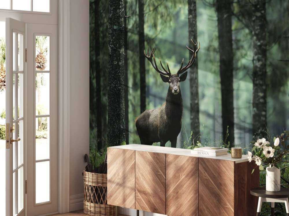 Duży jeleń między drzewami