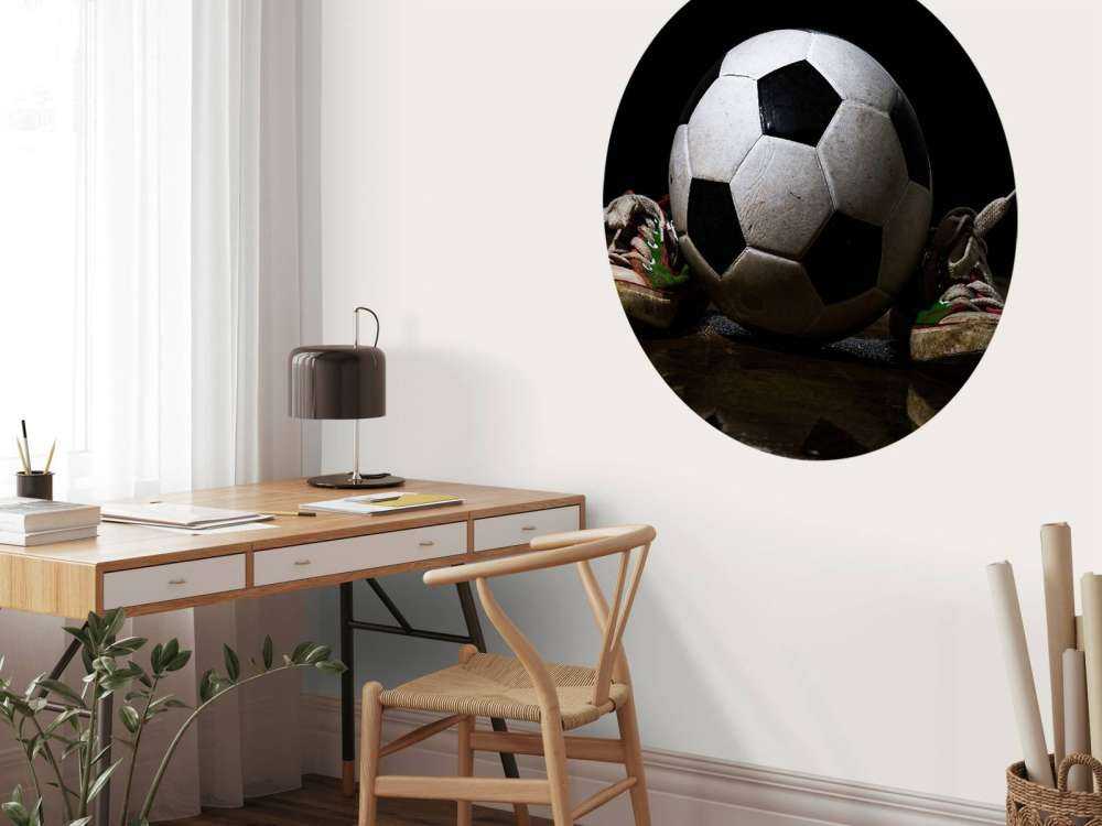 Piłka nożna pomiędzy dwoma trampkami